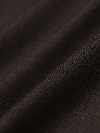 Nærbillede af mørkebrune Motion Suit-bukser i Regular Cognac-stof med 360°-stretch og bløde folder.