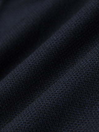 Nærbillede af Motion Suit-bukser i Regular-pasform i farven Midnight Blue, fremstillet af marineblåt 360°-stretchstof med et fint, struktureret væv.