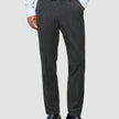 En person har grå Motion Suit-bukser i farven Regular Pepper Grey på, en hvid skjorte med knapper og sorte læderloafers.