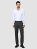 En mand i en hvid skjorte med knapper og et par Motion Suit-bukser i farven Regular Pepper Grey.