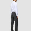 En mand i en hvid skjorte og grå Motion Suit-bukser i Regular-pasform i farven Pepper Grey ses i profil.