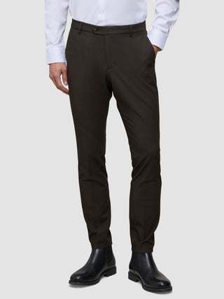 Brune Motion-bukser i slim fit i farven Slim Cognac, kombineret med en hvid skjorte med knapper og sorte støvler.