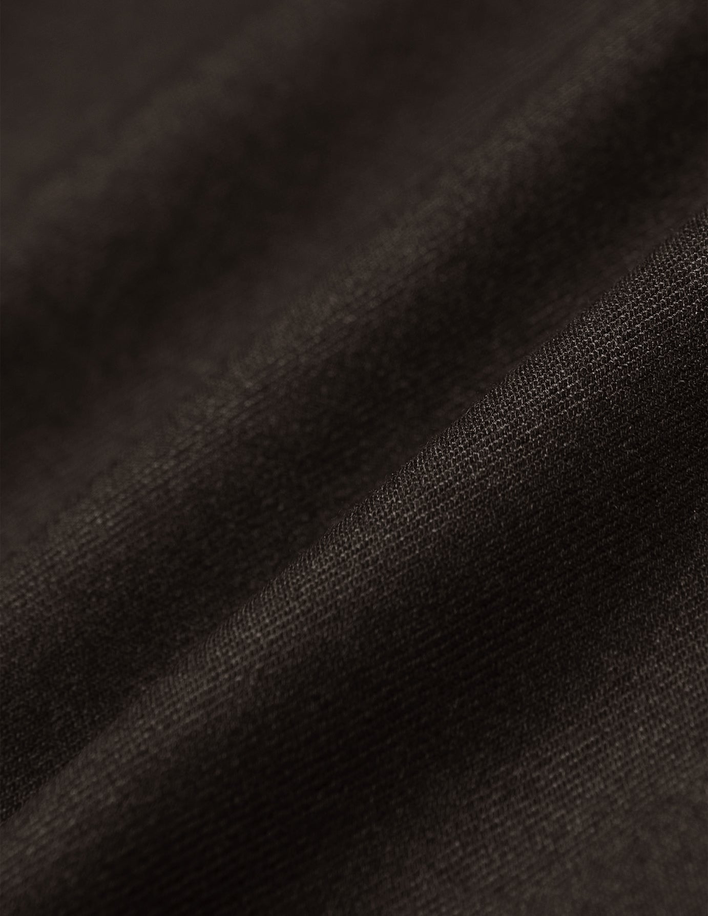 Nærbillede af brune Motion Suit-bukser i Slim Cognac-stretchstof med bløde 360°-folder.