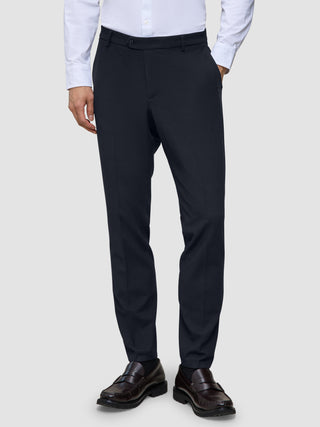 Slim-fit Motion Suit-bukser i farven Slim Midnight Blue med 360°-stretch, kombineret med en lys skjorte og mørke loafers.