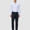 En mand iført en hvid skjorte med knapper, Motion Suit-bukser i slim fit i midnatsblå og mørkebrune loafers.
