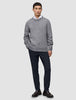 En mand har en grå trøje, en hvid skjorte, Motion Suit-bukser i slim fit i midnatsblå og mørke læderloafers på.