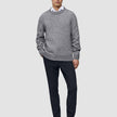 En mand har en grå trøje, en hvid skjorte, Motion Suit-bukser i slim fit i midnatsblå og mørke læderloafers på.