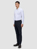En mand i en hvid skjorte med knapper og et par Motion Suit-bukser i slim fit i midnatsblå, der fremhæver klassisk dansk design.