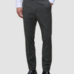 Motion Suit-bukser i Slim-pasform i farven Pepper Grey i mørkegrå med 360°-stretch, kombineret med en hvid skjorte med knapper og sorte loafers.