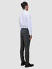 En mand i en hvid skjorte med knapper og grå Motion Suit-bukser i farven Slim Pepper Grey står med ryggen til kameraet.