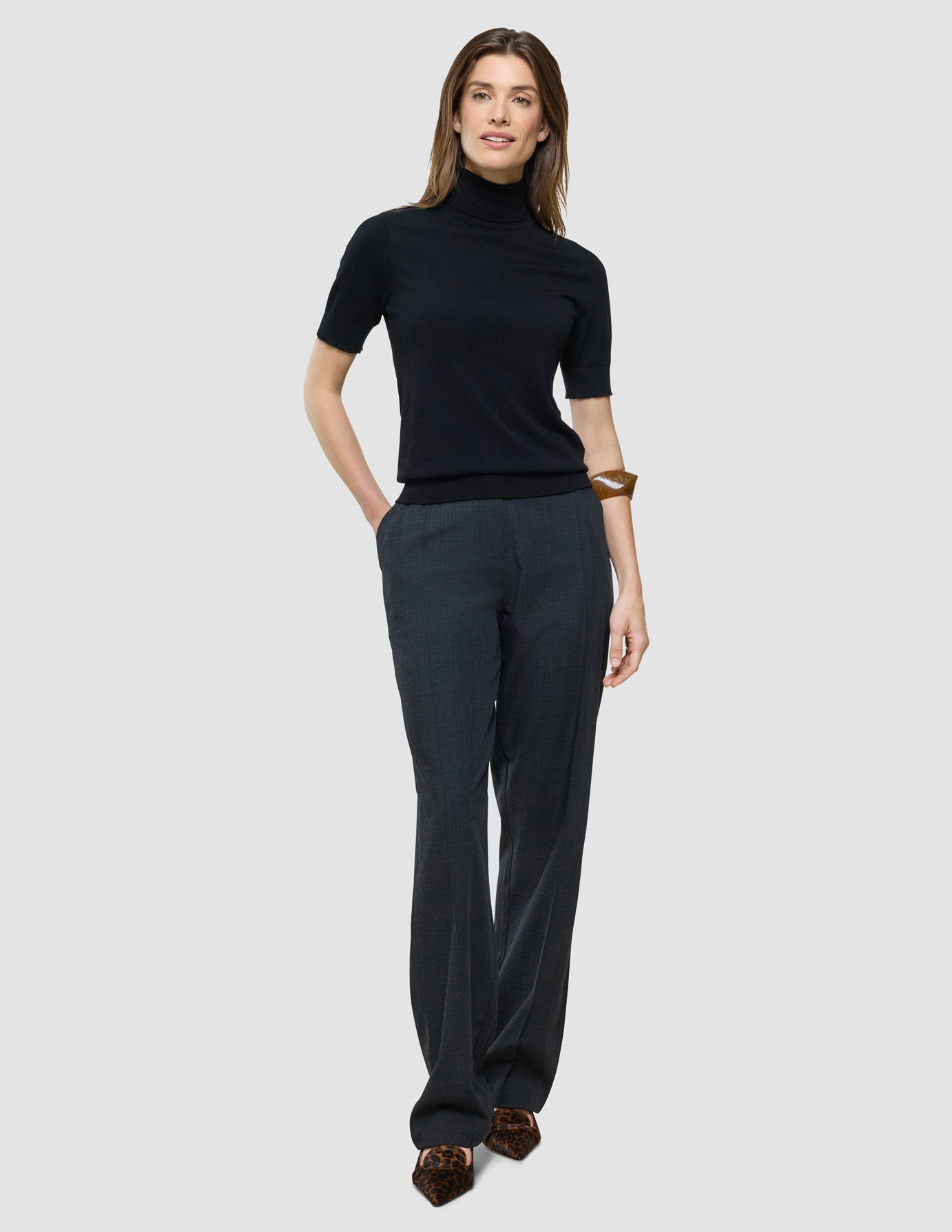 Quinn Turtleneck Short Sleeved i Black, helfigur fra foran med hænderne i lommerne.