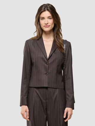 En kvinde iført en »Women Raina Short Blazer« i farven Chestnut med tynde striber.