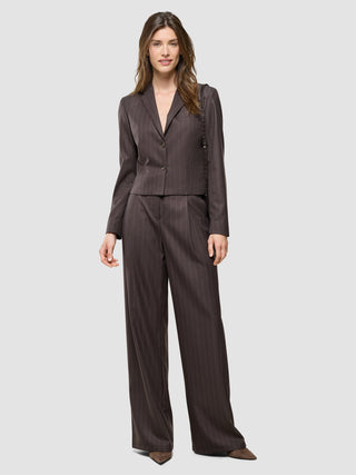 En kvinde iført en Women Raina Short Blazer i farven Chestnut Pinstripe sammen med et par matchende bukser med brede ben.