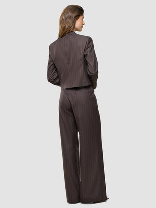 En kvinde set bagfra, iført en »Women Raina Short Blazer« i farven Chestnut med nålestriber og et par matchende bukser med brede ben.