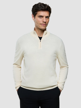 En mand iført en Seamless Core Knit Half Zip Birchwood over en sort skjorte.