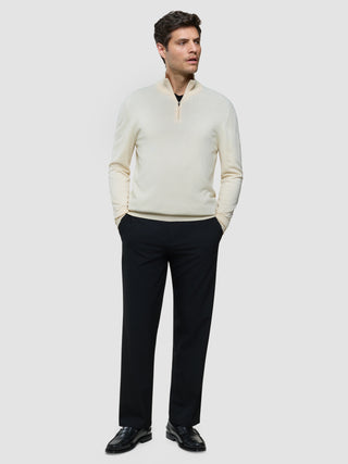 En mand iført en Seamless Core Knit Half Zip Birchwood, sorte bukser og sorte loafers.