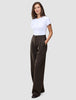En kvinde iført en hvid T-shirt og et par Serene Pants Wide Walnut Herringbone-bukser med høj talje og brede ben i nålestribet mønster.