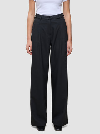 Person iført en hvid T-shirt og et par Serene Pants Wide Black med læg foran.