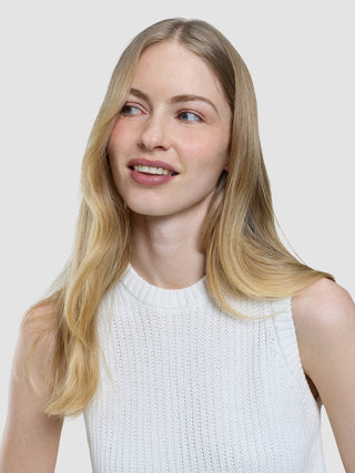 En kvinde med blondt hår, der har en struktureret strikbluse i offwhite til kvinder på, kigger væk fra kameraet.