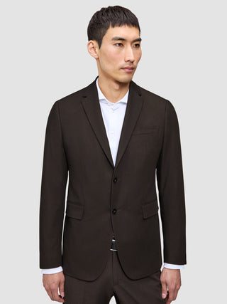 En mand iført Motion Suit-jakken – den jakke, der kan det hele – over en stiv, elegant hvid skjorte.