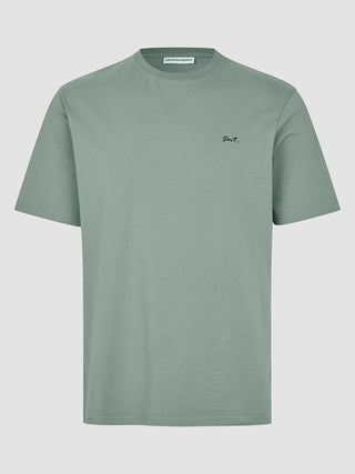 Supima Legacy T-shirt i farven »Mist Green« med et lille sort Snt.-logo broderet på brystet.