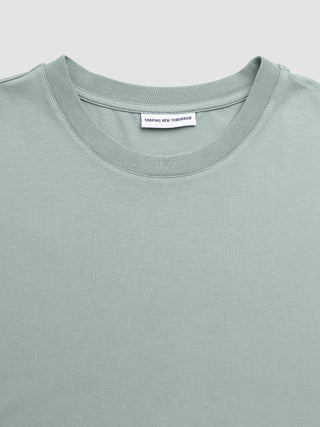Supima Legacy T-shirt i farven »Mist Green« med en »Shaping New Tomorrow«-halsmærkat.
