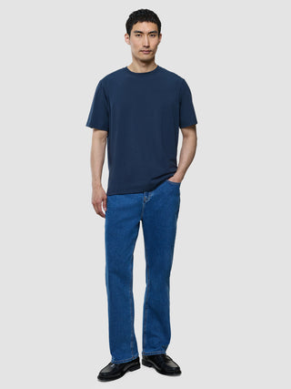 Supima T-Shirt Box Fit i Navy, mand i helfigur iført marineblå t-shirt og blå jeans.