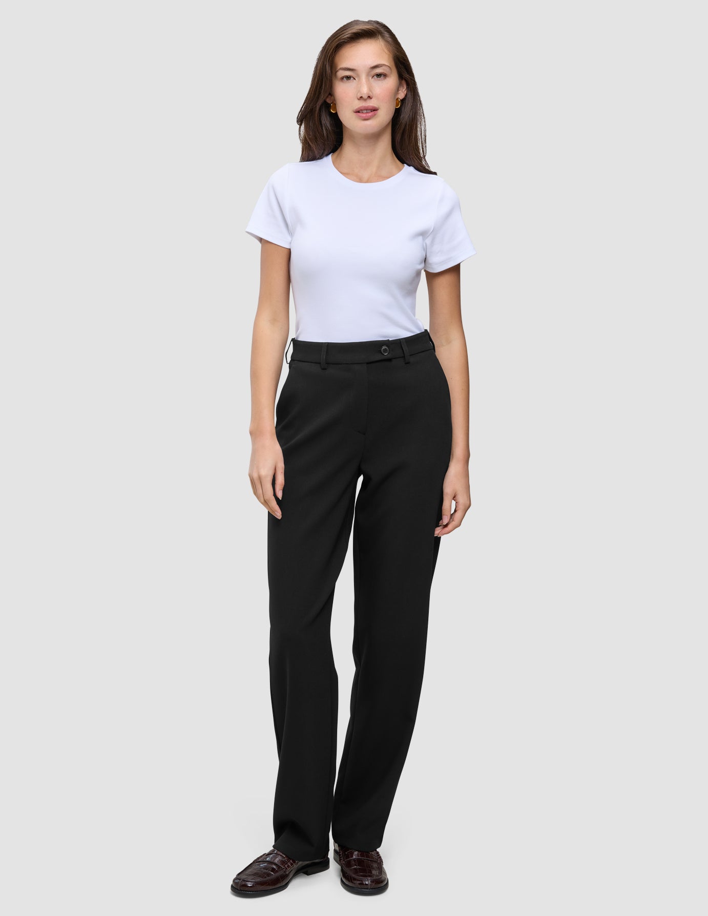 En kvinde har en hvid T-shirt på og et par Women GO2 Pants Straight Black, der har høj talje og lige ben.