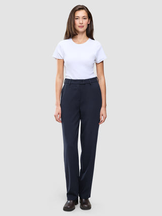 En kvinde iført en hvid T-shirt og Women GO2 Pants Straight Blue Nights i mørk marineblå.