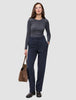 En kvinde i en grå langærmet bluse har Women GO2 Pants Straight Blue Nights på og holder en brun håndtaske.