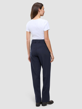En person set bagfra, iført en hvid T-shirt og et par Women GO2 Pants Straight Blue Nights med lige ben.