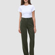 En kvinde i en hvid T-shirt, der er stukket ned i et par olivengrønne Women GO2-bukser i straight-fit i farven Dusty Olive, og mørke loafers.