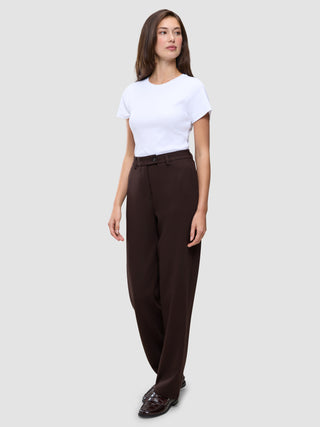 En kvinde iført en hvid T-shirt, mørkebrune Women GO2 Pants Straight Mocha og loafers.