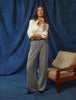 En kvinde har en hvid Women’s Oxford Shirt White Orchid Slim på, som er stukket ned i et par grå bukser med brede ben.