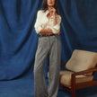 En kvinde har en hvid Women’s Oxford Shirt White Orchid Slim på, som er stukket ned i et par grå bukser med brede ben.