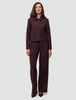 En kvinde iført en Women Serene Short Jacket i farven Berry Pinstripe og tilhørende bukser med brede ben i et minimalistisk dansk design.