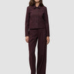 En kvinde iført en Women Serene Short Jacket i farven Berry Pinstripe og tilhørende bukser med brede ben i et minimalistisk dansk design.