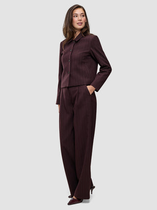 En kvinde bærer den korte jakke Women Serene Short Jacket Berry Pinstripe og de tilhørende bukser, der fremhæver det elegante danske design.