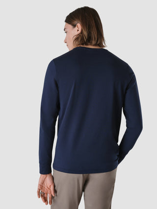 En person set bagfra iført en marineblå Supima Autograph langærmet T-shirt i et enkelt dansk design.