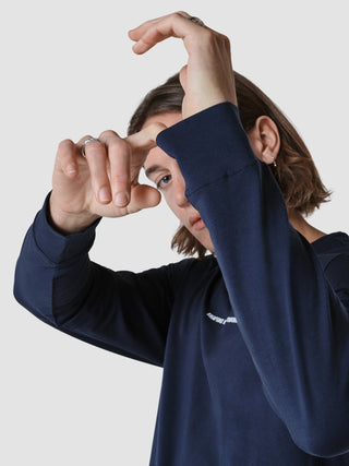 En person iført en marineblå Supima Autograph langærmet T-shirt danner et hjerte med hænderne foran ansigtet.