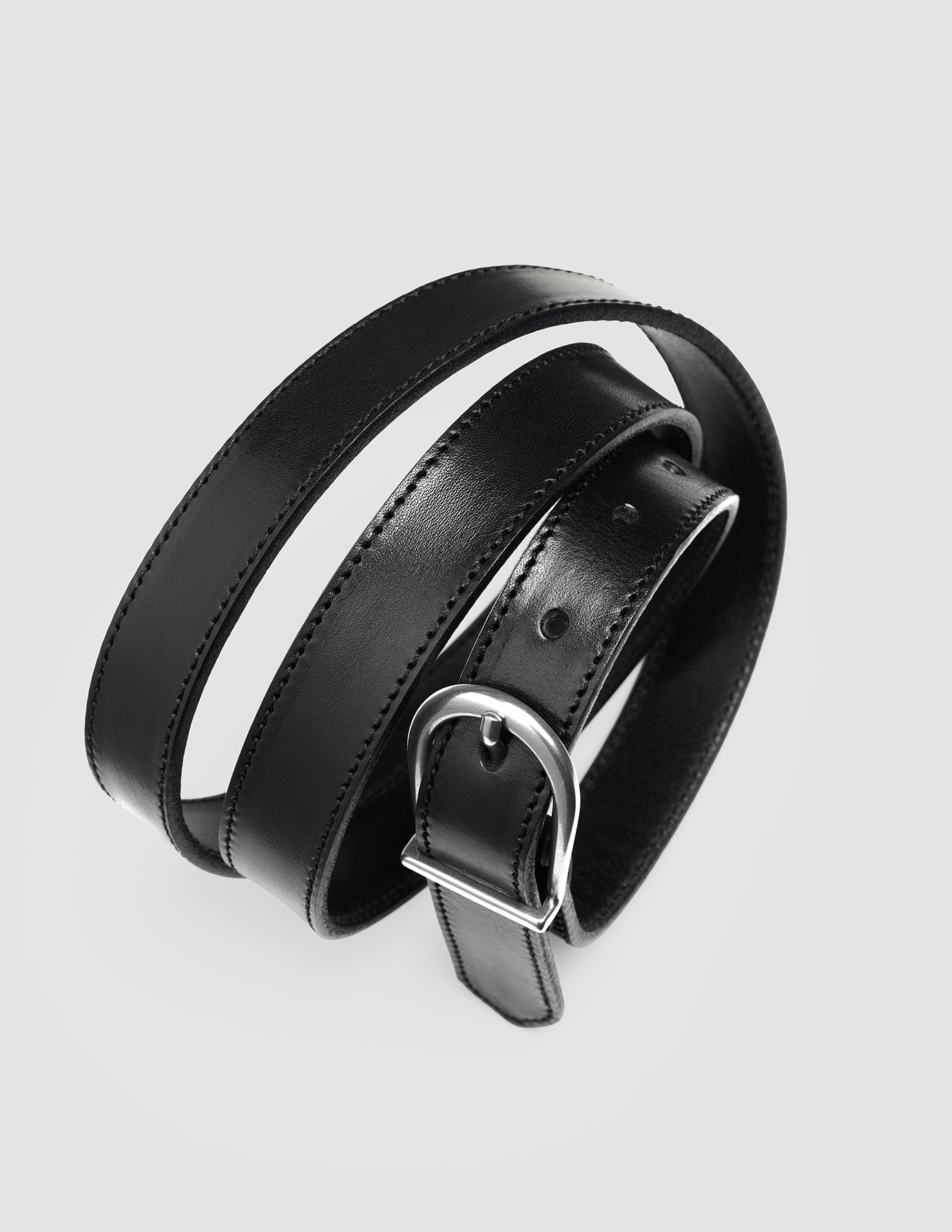 Et snoet, tyndt læderbælte til kvinder i sølv og sort med en sølvspænde, der er kendetegnet ved klassisk dansk design.
