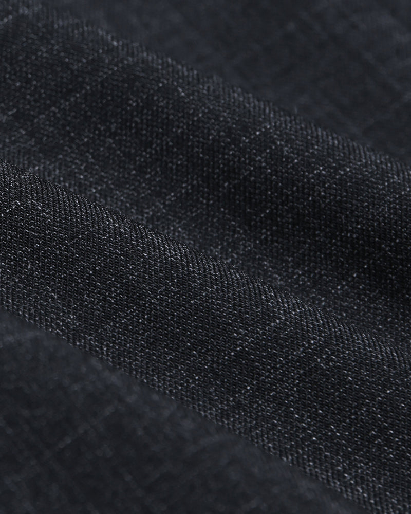 Nara Pants i sort, detalje af stofstruktur med diagonale folder.