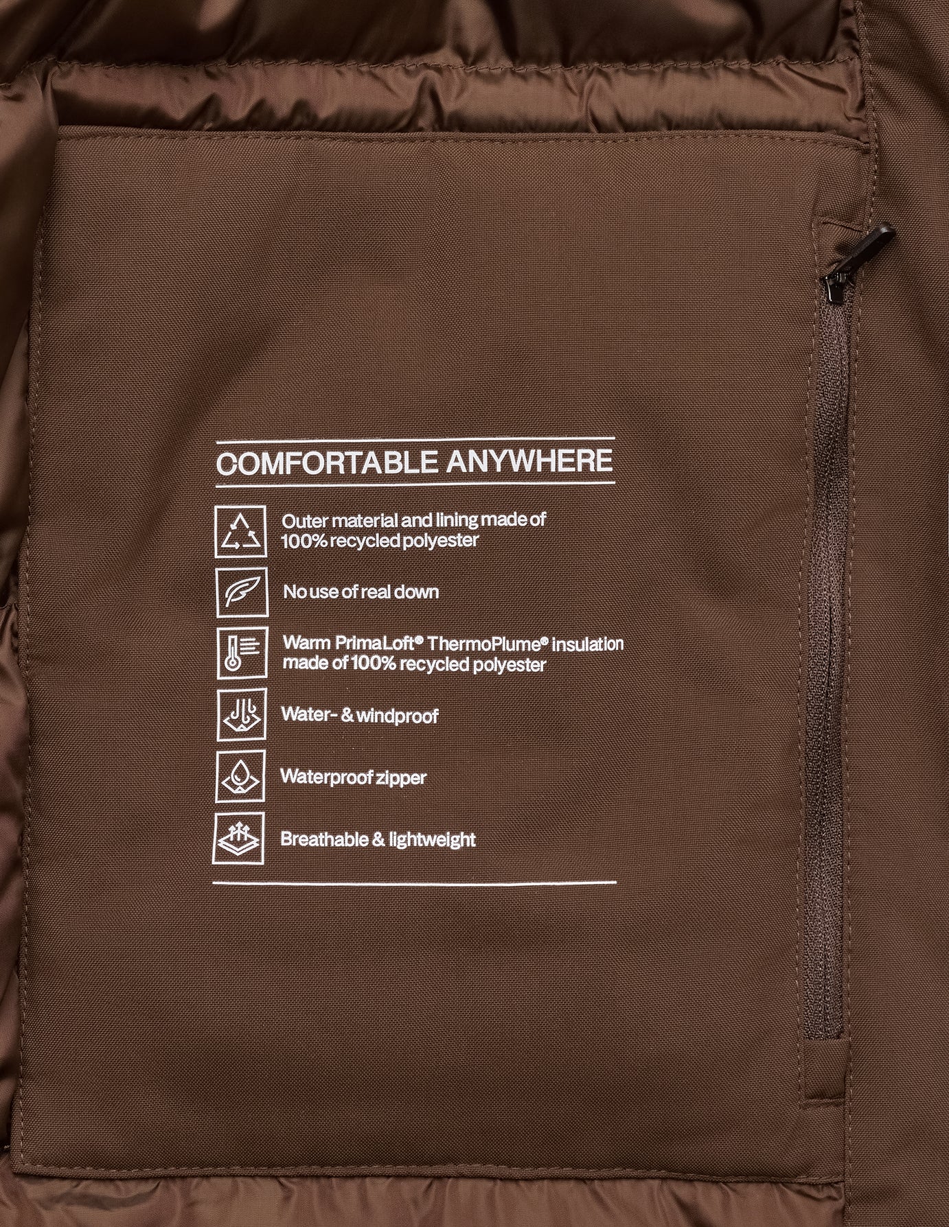 Indersiden af Utility Jacket i farven Saddle Brown med en lomme med lynlås og funktionelle detaljer i genanvendt polyester.