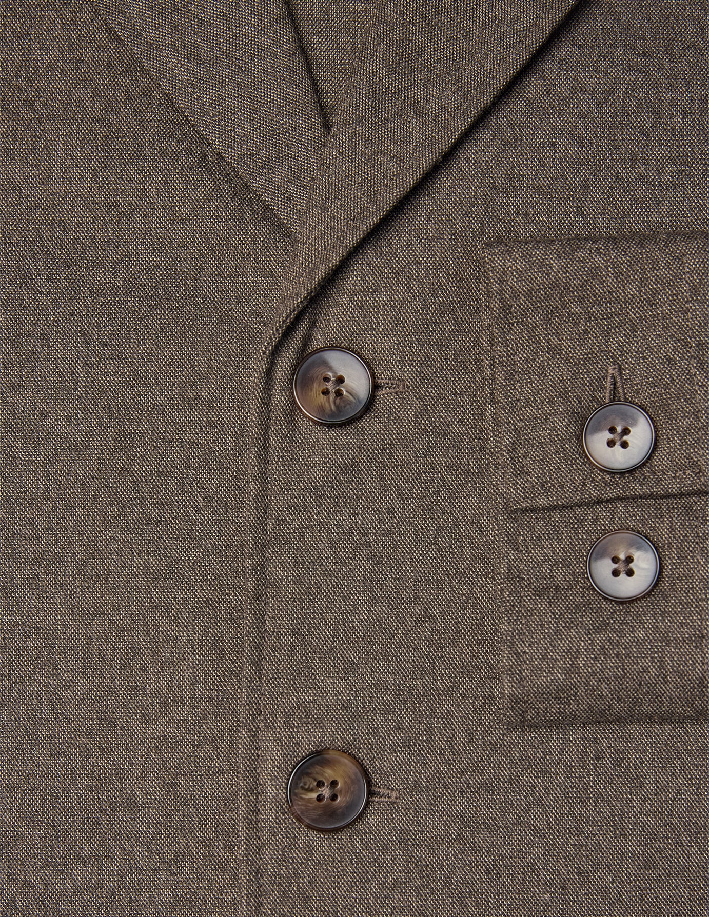 Nærbillede af Atelier Overshirt Dark Beige, en mørk beige blazer med to knapper foran og to knapper på brystlommen.