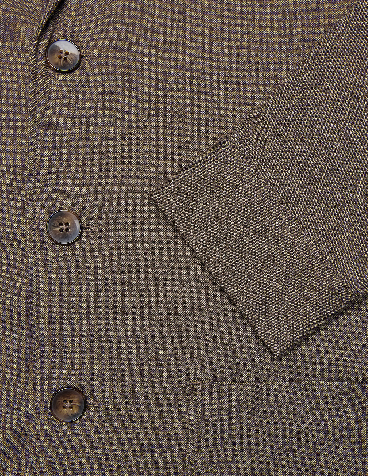 Nærbillede af den mørkebegige Atelier Overshirt-blazer med tre brune knapper og en lomme.