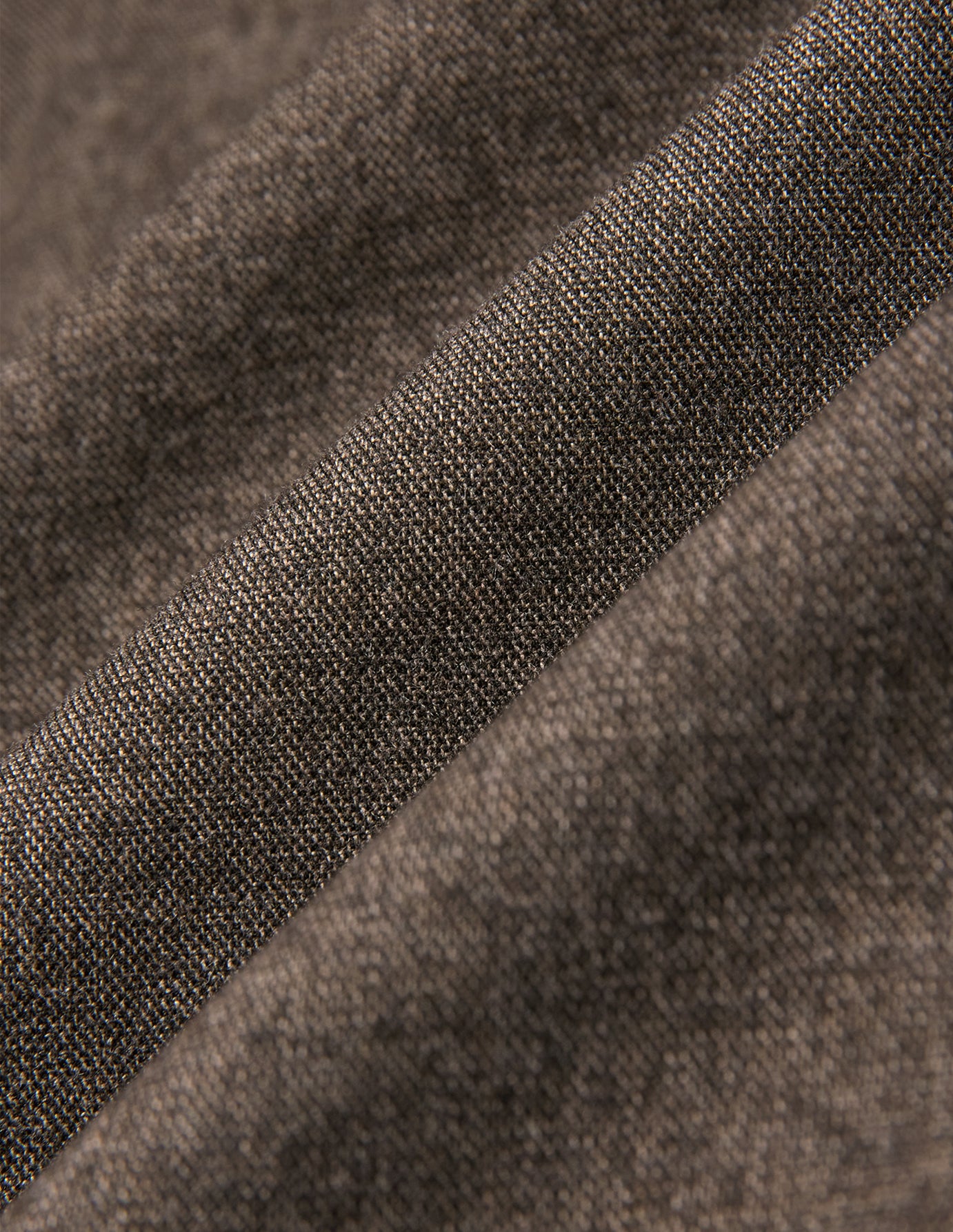 Nærbillede af det beige vævede stof på en Atelier Overshirt i mørk beige.