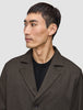 En mand, der har en mørkebrun Atelier Overshirt på over en sort sweater.