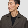 En mand, der har en mørkebrun Atelier Overshirt på over en sort sweater.