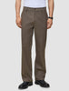 En mand iført et par Atelier Pants Relaxed Dark Beige i kraftigt, brudt twill og håndlavede sorte lædersko fra Portugal.
