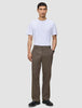 En mand i en hvid T-shirt, mørkebegige Atelier Pants Relaxed og sorte sko.